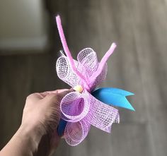 a hand holding a pink and blue pinwheel