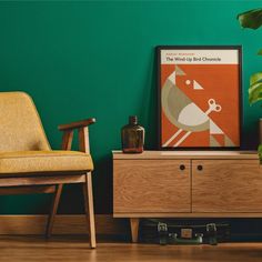 a living room with green walls and a wooden dresser next to a yellow chair in the corner