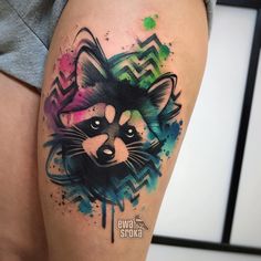 a colorful raccoon tattoo on the thigh