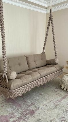 a living room with a couch, rug and chair hanging from it's ceiling