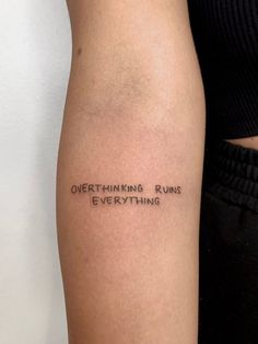 a woman's arm with the words, overthiking runs everything on it