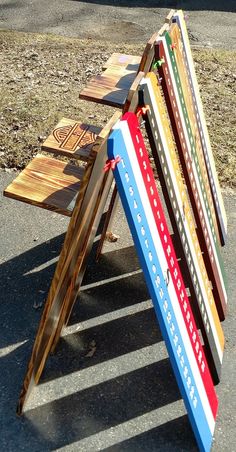 a multicolored wooden bench sitting on the side of a road