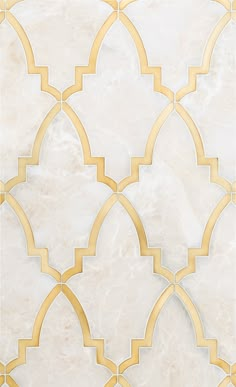 a white and gold tile wall with an intricate design