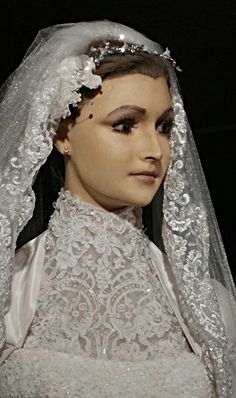 a mannequin wearing a wedding dress and veil