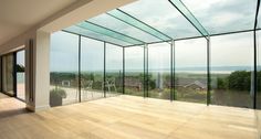 an empty room with glass walls overlooking the ocean