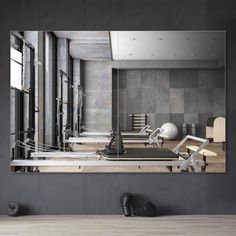 an empty gym room with mirrors and exercise equipment on the floor in front of it