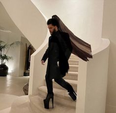 a man is walking down the stairs with his coat over his head and shoes on