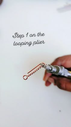 a person holding a pair of scissors in their left hand with the words step 1 on the looping plier