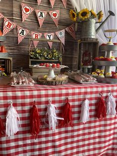 a red and white checkered table cloth with tassels hanging from it's sides