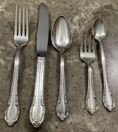 four forks, two spoons and one knife on a table