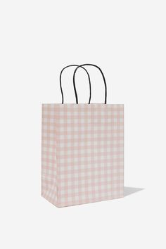 a pink and white gingham shopping bag with black handles on an isolated background