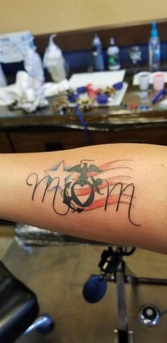 a woman's arm with the word mom written in cursive writing on it