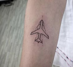 a small airplane tattoo on the arm