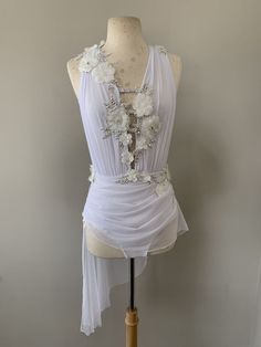 a mannequin wearing a white dress with flowers on it's neckline