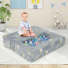 a baby sitting on top of an inflatable ball pit