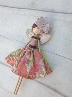 a doll is holding a flower on a stick