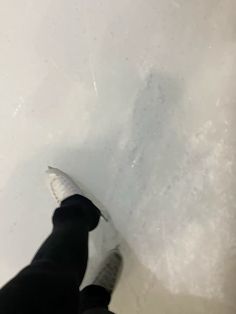 a person standing on top of a snow covered slope with their feet in the air