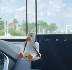 a toy duck hanging from the dashboard of a car