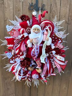 a wreath with santa claus on it hanging from a wooden fence in front of a door