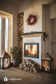 a living room with a fire place next to a pile of logs and a wreath on the wall