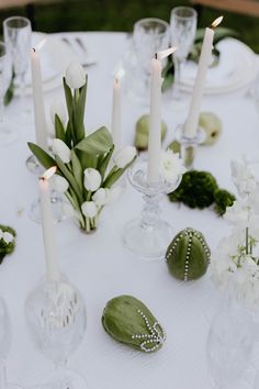 the table is set with white flowers and candles