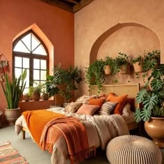 an orange bedroom with potted plants on the wall and a bed covered in blankets