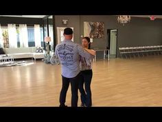 a man and woman are dancing in an empty room