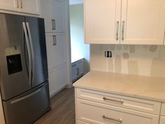 a kitchen with white cabinets and stainless steel appliances