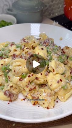 a white plate topped with macaroni and cheese covered in green onions next to broccoli