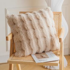 a white pillow sitting on top of a wooden chair