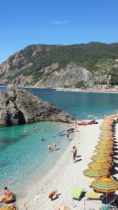 many people are on the beach with umbrellas and sunbathers in the water