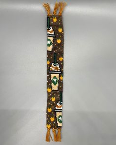 a brown and green beaded bookmark hanging from a hook