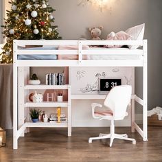 a white bunk bed sitting next to a christmas tree