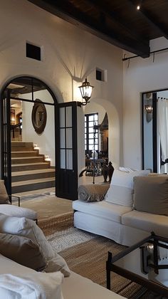 a living room filled with white furniture and lots of pillows on top of it's couches