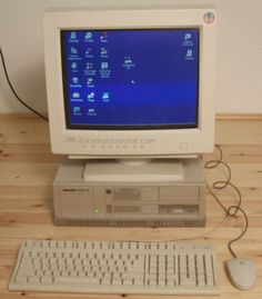 a desktop computer sitting on top of a wooden desk next to a keyboard and mouse