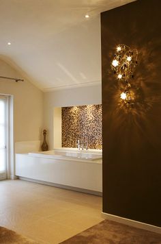 a bathroom with a large bath tub sitting next to a wall mounted vanity and mirror