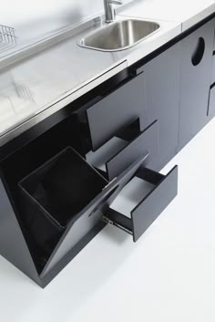 an open drawer on the side of a kitchen counter with a sink and faucet