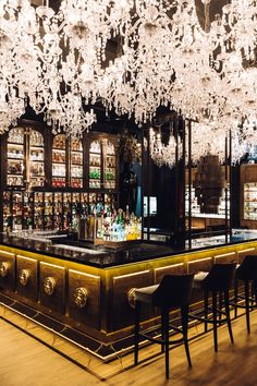 a bar with chandeliers hanging from the ceiling