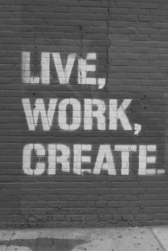 the words live, work, create are spray painted on a brick wall