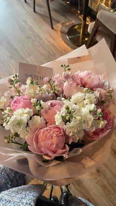 a bouquet of pink and white flowers sitting on top of a table