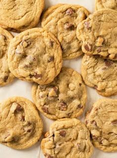 a bunch of cookies sitting on top of a white tablecloth next to each other