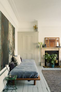 a bedroom with a bed, fireplace and painting on the wall