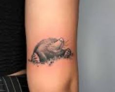 a small bear tattoo on the arm