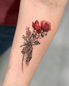 a woman's arm with red flowers and a tattoo on the wrist that says, i love you