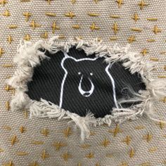 a piece of cloth with a bear drawn on it and some yellow crosses in the background