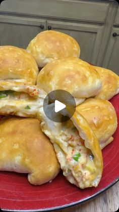 a red plate topped with cheesy pastries on top of a wooden table