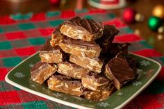 a plate full of chocolate and peanut butter bars on a table with christmas decorations in the background