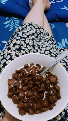 a bowl of cereal is sitting on someone's lap