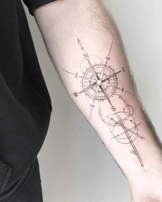 a man's arm with a compass tattoo on it