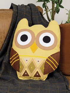 an owl pillow sitting on top of a couch